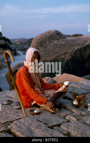 Indien, Karnataka, Hampi. Ein wandernder Asket oder Sadhu erwartet Almosen in der Nähe der Ufer des Flusses Tungbhadra Stockfoto