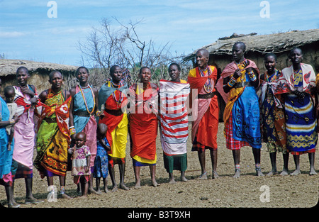 Afrika, Kenia, Masai Mara National Wildlife Reserve. Frauen und Kinder stellen in Masai Mara Dorf. Stockfoto