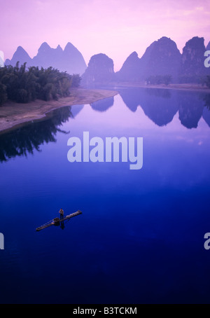 Asien, China, Guanxi, Yangshou. Fischer auf Floß in Li-Fluss. Stockfoto