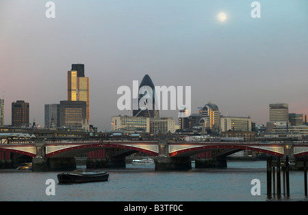 England, London. Ein Vollmond steigt über der Themse, mit Blackfriars Bridge, Tower 42 und die Gurke in 33 St Mary Axe im Hintergrund. Stockfoto