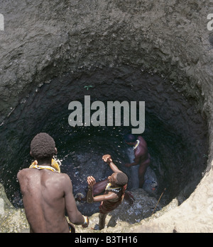 Tansania, Norden von Tansania, Tiefe Maasai Brunnen am Loibor Serrit wo Rinder Wege tief in den Boden Tiere näher an der Quelle des Wassers ermöglichen geschnitten werden. Trotz dieser immensen Menge Handarbeit die meisten Brunnen sind Vierer-Brunnen - das heißt vier Fit, junge Männer sind notwendig, um Wasser in die Lager Tröge etwa 30 Fuß oberhalb des Wasserspiegels an der Unterseite der Hand gegrabenen Brunnen zu bringen. Stockfoto