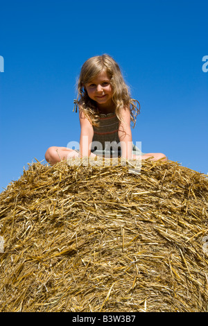 Mädchen sitzen auf einem Heuballen Stockfoto