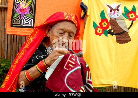 Mittelamerika, Panama, San Blas Inseln (aka Kuna Yala). Lokalen Kuna Frau genäht mit Rohr bunte Blatt Mola. Stockfoto