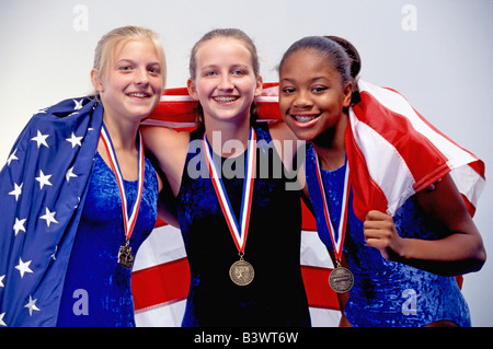 Preisgekrönte Turnerinnen drapieren sich in amerikanische Flagge Stockfoto