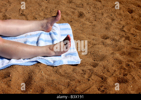 Damen-Beine und Füße, Sonnenbaden am Strand Stockfoto