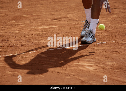 Schatten ein Tennisspieler Prellen den Ball vor dem Gottesdienst auf einem Sand Stockfoto