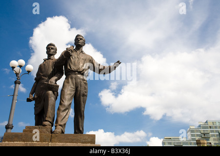 Zwei bronze Sozialrealismus Skulpturen Geste kühn vor Gebäuden und einem blauen Himmel in Vilnius Litauen über die Grüne Brücke. Stockfoto