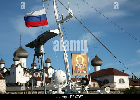 Russische Flagge und die Ikone des Heiligen Nikolaus auf dem Pilger Schiff vor dem Solovetsky Kloster im Weißen Meer, Russland Stockfoto