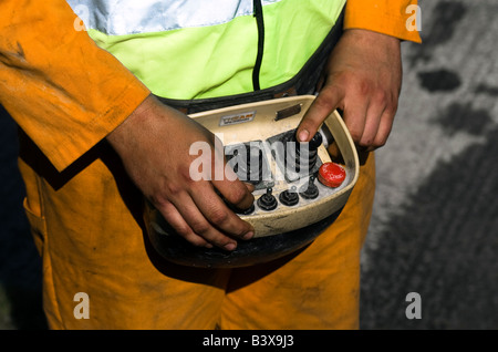 Ein Arbeiter ist der Beton Betonmischer aus der Ferne in Betrieb durch Drücken der Tasten auf seinem remote-system Stockfoto