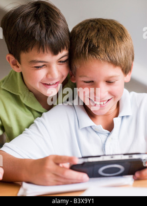 Zwei jungen mit einem Handheld-Video-Spiel spielen Stockfoto