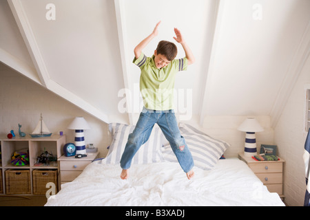 Junge, springen auf Bett Stockfoto