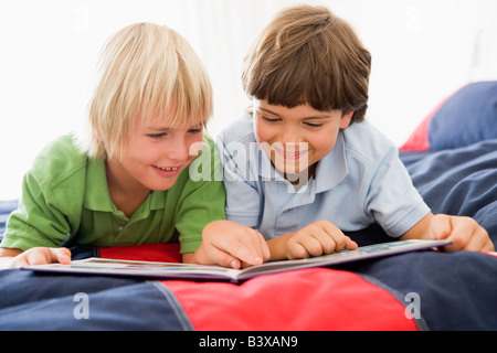 Zwei jungen, liegend auf einem Bett und las ein Buch Stockfoto