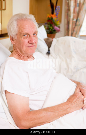 Ältere Mann sitzt im Krankenhausbett Stockfoto