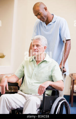 Krankenschwester schob Mann im Rollstuhl Stockfoto