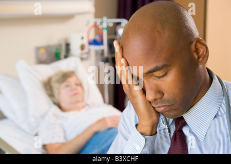 Arzt suchen müde und frustriert im Krankenzimmer Stockfoto
