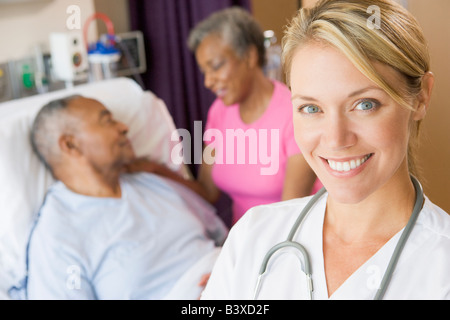 Arzt lächelnd, stehend im Patienten-Zimmer Stockfoto