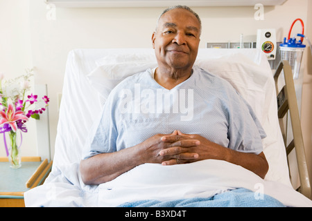 Ältere Mann sitzt im Krankenhausbett Stockfoto