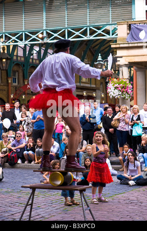 Straßenkünstler unterhält, Touristen und Passanten Covent Garden London Vereinigtes Königreich Stockfoto