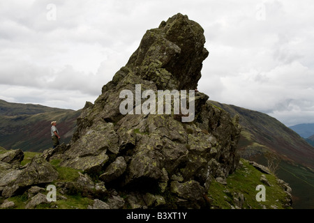 Wanderer, die Gipfel der Helm Crag auch bekannt als The Haubitze oder Lion Couchant Betrachtung Stockfoto