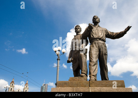 Zwei bronze Sozialrealismus Skulpturen Geste kühn vor Gebäuden und einem blauen Himmel in Vilnius Litauen über die Grüne Brücke. Stockfoto