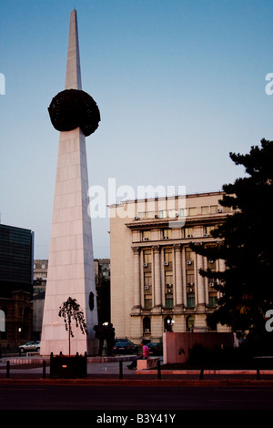 Ein junger Mann sitzt am Obelisk Denkmal an der Piata Revolutiei Piata Revolutiei in Bukarest Rumänien Stockfoto