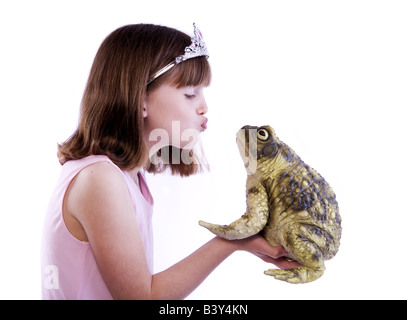 Junge Mädchen wie eine Prinzessin mit Kröte oder Frosch gab es einen Kuss isoliert auf weißem Hintergrund Stockfoto