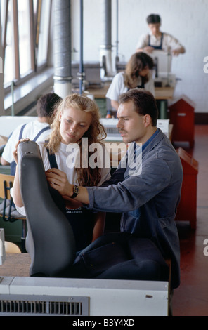 Weiblichen Lehrling bei Porsche in Stuttgart, Deutschland, arbeitet auf dem Polster des Sitzes unter Anleitung eines Trainers Stockfoto