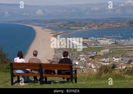 Touristen genießen die spektakuläre Aussicht auf die berühmten Chesil Beach (auf der linken Seite) und Portland Harbour (rechts) in Dorset Stockfoto