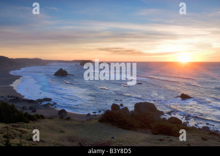 Sonnenuntergang und Wellen vom Blacklock Punkt mit Cape Blanco im Hintergrund Oregon Stockfoto