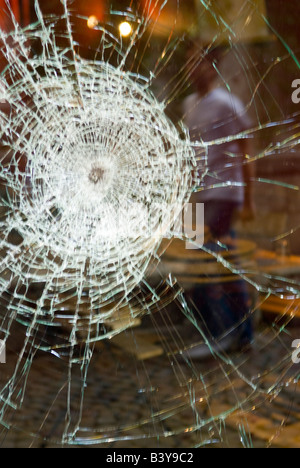 Zerbrochenes Fenster reflektiert das Leben auf der Straße vorbei. Stockfoto