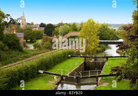 Bei wenig Bedwyn auf der Kennet und Avon Kanal mit Dorf und Kirche in der Ferne zu sperren.  Wiltshire, England, Vereinigtes Königreich Stockfoto