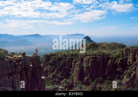 Südafrika, große Karoo Karoo Nature Reserve. Kletterer mit Blick auf Valley of Desolation, ein Wind erodiert Bereich auswarfen Gipfeln, Säulen und ausgleichende Felsen in der Nähe von Graaff-Reinet Stockfoto