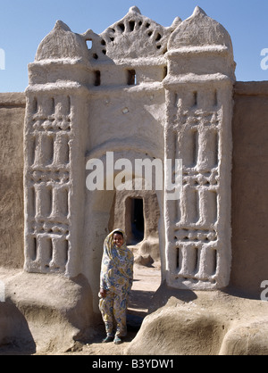 Sudan, Sahara Wüste Qubbat Selim. Einem nubischen Mädchen Stand in einem Torbogen am Dorf Qubbat Selim. Traditionellen nubischen Architektur. Traditionellen nubischen Architektur und Stuckarbeiten von einer feinen Torbogen zu einem Haus und seinen Hof in Qubbat Selim. Stockfoto