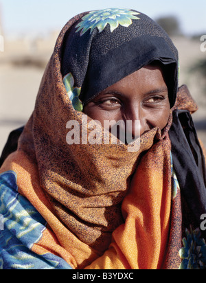 Sudan, Sahara Wüste Qubbat Selim. Eine attraktive nubische Frau in helle Kleidung, der untere Teil des Gesichts bedeckt von dem Kopftuch. Stockfoto