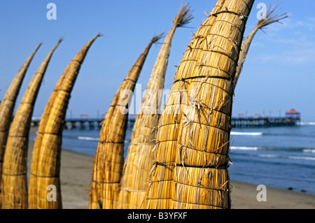 Peru, La Libertad, Huanchaco. Caballitos de Totora (Reed Boote) sind entlang des Strandes bei Huanchaco im Norden Perus trocknen gestapelt. Die Boote haben seit mehr als zweitausend Jahren von den Fischern an der Nordküste Perus eingesetzt. Stockfoto