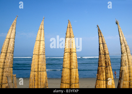 Peru, La Libertad, Huanchaco. Caballitos de Totora (Reed Boote) sind entlang des Strandes bei Huanchaco im Norden Perus trocknen gestapelt. Die Boote haben seit mehr als zweitausend Jahren von den Fischern an der Nordküste Perus eingesetzt. Stockfoto