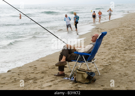 Canet Plage nr. Perpignan, Südfrankreich, älterer Angelmann, der auf einem Liegestuhl sitzt. Strandszene stürmisches Wetter HOMER SYKES Stockfoto