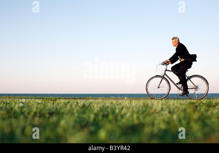 Mann im Anzug fährt Rad entlang Chicago Lakefront in der Abenddämmerung Stockfoto