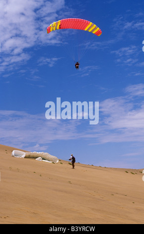 Namibia, Skeleton Coast. Paragliding über die Dünen der Namib-Wüste, wo sie die onshore Küstenwinde treffen Stockfoto