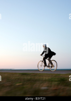 Mann im Anzug mit Fahrrad entlang der Seepromenade in Chicago in der Abenddämmerung (gesunder Lebensstil) Stockfoto