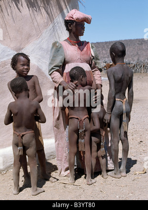 Namibia, Damaraland, Palmwag. Ein Herero-Frauen und Kinder. Die aufwändige Kleider und einzigartigen Hut Stile der Herero-Frauen können t werden. Stockfoto