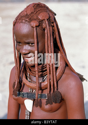 Namibia, Kaokoland, Empembe. Ein Himba-Mädchen in traditioneller Kleidung.  Ihr Körper glänzt aus einer Mischung von rotem Ocker, Butterfett eine Stockfoto