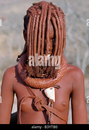 Namibia, Kaokoland, Empembe. Ein Himba-Mädchen in traditioneller Kleidung.  Ihr Körper glänzt aus einer Mischung von rotem Ocker, Butterfett eine Stockfoto