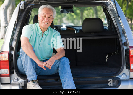 Mann sitzt auf der Rückseite van lächelnd Stockfoto