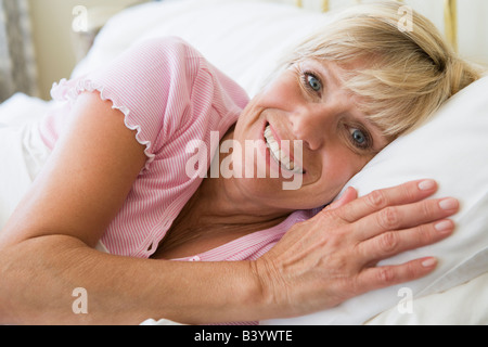 Frau liegend im Bett lächelnd Stockfoto