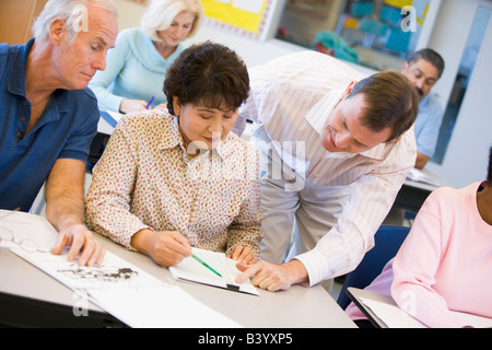 Lehrer in der Klasse, die Unterstützung von Erwachsenen Studierenden (Tiefenschärfe) Stockfoto