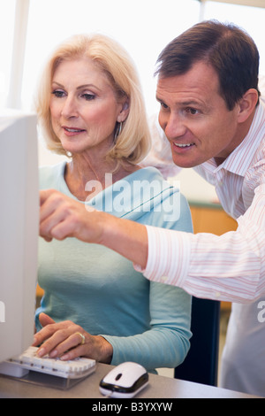 Mann und Frau am Computer schreiben und zeigen (high-Key) Stockfoto