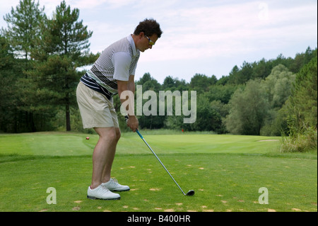 Golfer, die Adressierung des Balls, wie er mit einem Bügeleisen auf einem kurzen Abschlag soll par drei Stockfoto