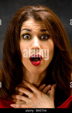 Schöne Frau mit schockiert Ausdruck gekleidet und offenem Mund und Hände auf Brust Stockfoto