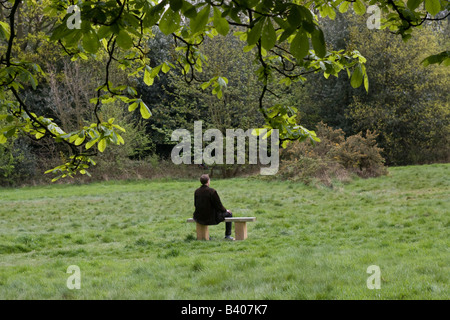 Einsamer Mann auf der Parkbank sitzen Stockfoto